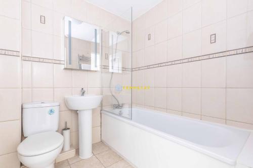 a bathroom with a toilet and a tub and a sink at Heathrow Apartment - private balcony & FREE PARKING! in Slough