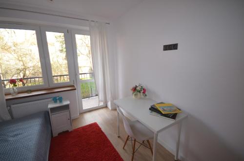 a bedroom with a desk and a bed and a window at Blue Sail Sopot Apartments in Sopot