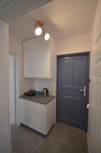 a kitchen with a black door and a black counter at Blue Sail Sopot Apartments in Sopot