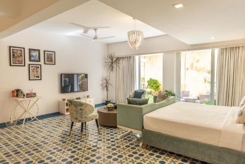 a bedroom with a bed and a couch and a chair at La Mer Apartments in Nerul