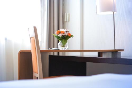 a vase filled with flowers sitting on a table at Novotel Budapest Danube in Budapest