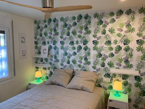 a bedroom with a bed with a wall covered in plants at Mas PineII 2 - Viu Bé in Torroella de Montgrí