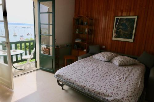 レージュ・キャップ・フェレにあるComfortable, renovated Studio in top Cap Ferret location, 1st line with bay viewのベッドとバルコニーのある寝室