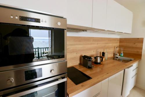 une cuisine avec une cuisinière et un comptoir dans l'établissement Comfortable, renovated Studio in top Cap Ferret location, 1st line with bay view, à Lège-Cap-Ferret