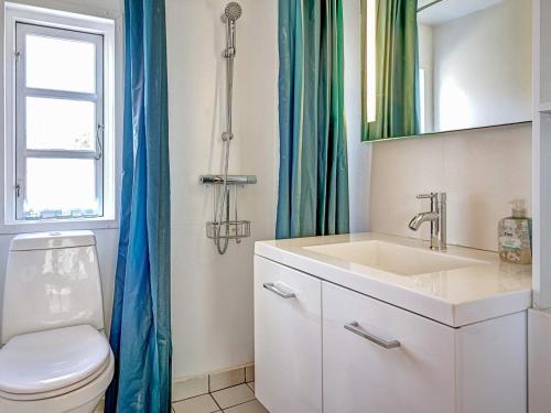 a bathroom with a toilet and a sink and a window at Three-Bedroom Holiday home in Gørlev 7 in Rønne