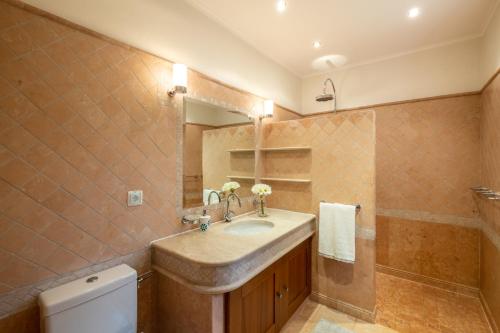 W łazience znajduje się umywalka, lustro i toaleta. w obiekcie Casa Amada - Private Villa - Heated pool - Free wifi - Air Con w mieście Silves
