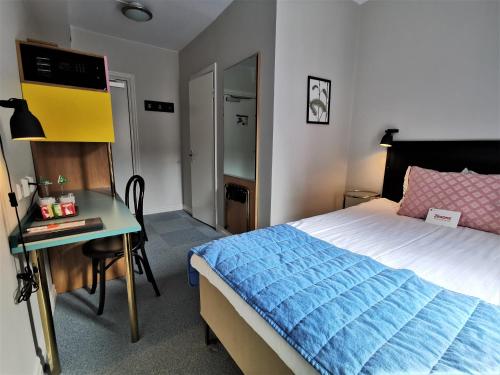 a bedroom with a bed and a desk with a desk at 2Home Hotel Gävle in Gävle