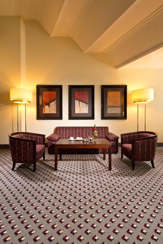 a living room with two couches and a table and two chairs at Maritim Hotel Bad Homburg in Bad Homburg vor der Höhe