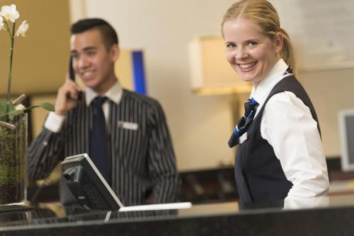 a man and a woman standing in front of a desk at Maritim Hotel Bad Homburg in Bad Homburg vor der Höhe