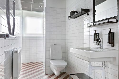 a white bathroom with a toilet and a sink at Hotel Giò; BW Signature Collection in Solna