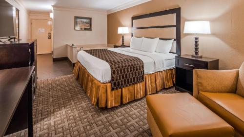 una camera d'albergo con un grande letto e un divano di Best Western Riverside Inn a Macon