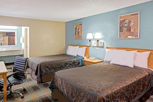 拉德森的住宿－萊德森戴斯酒店，酒店客房,设有两张床、一张桌子和椅子