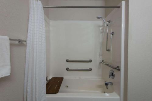 a bathroom with a shower and a bath tub at La Quinta by Wyndham Erie in Erie