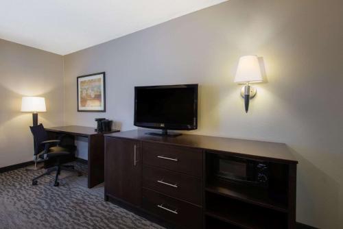 a hotel room with a desk with a television and a deskictericter at La Quinta by Wyndham Erie in Erie