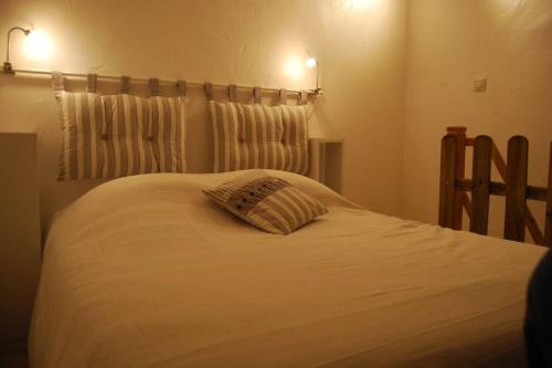 a bedroom with a bed with a pillow on it at L'Atelier à 100 m de Tarbes sud in Laloubère