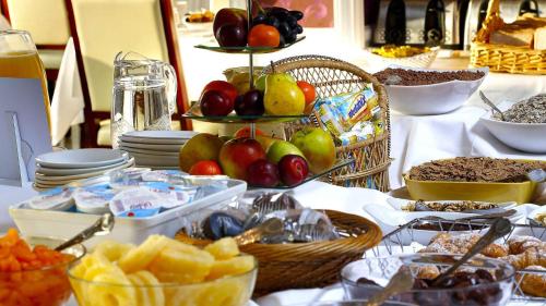 a table with a buffet of fruit and other food at OYO Stade Court Hotel in Hythe