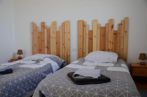 two beds in a room with wooden walls at Maison proche de la mer, Normandie in Surville