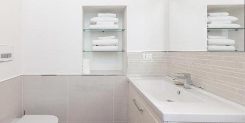 łazienka z umywalką, toaletą i ręcznikami w obiekcie Libri Flat w Rzymie