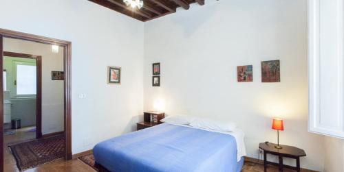 a bedroom with a blue bed and a mirror at Libri Flat in Rome