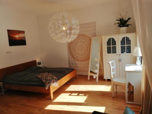 a bedroom with a bed and a chandelier at Privé sauna & terras - Aachen Vaals Drielandenpunt in Vaals