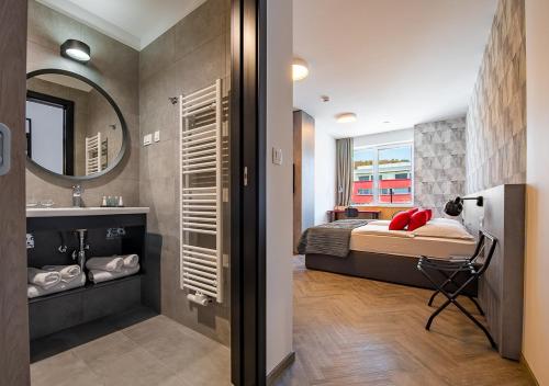 a bedroom with a bed and a sink and a mirror at Urban Ring Hotel in Ljubljana