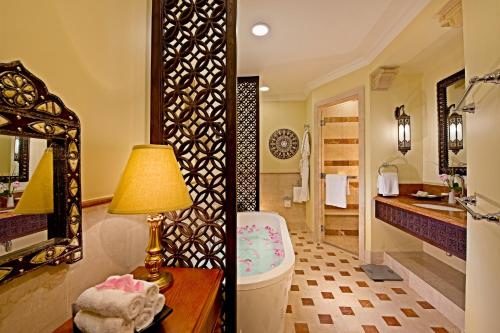 a bathroom with a sink and a toilet and a mirror at Djibouti Palace Kempinski in Djibouti