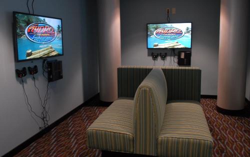 a living room with a couch and two televisions at Holiday Inn Express Boise Downtown by IHG in Boise