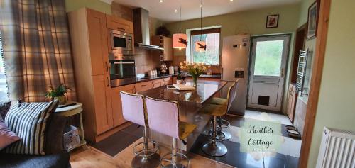 uma cozinha com uma mesa e cadeiras em Heather Cottage Aberdeen em Aberdeen