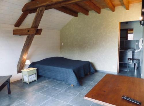 a bedroom with a blue bed and a wooden ceiling at La Grange de l’Ouche in Saint-Parize-le-Châtel