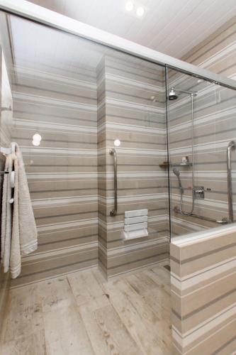 a bathroom with a shower with a glass wall at Pousada Chácara Aracê in Araras Petropolis
