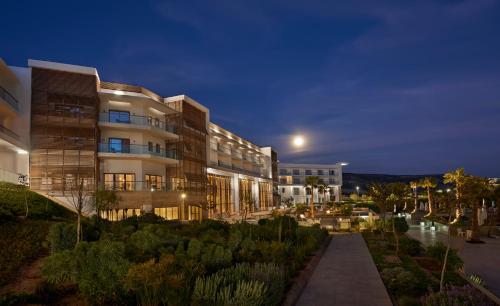 a large building at night with a garden at Hyatt Place Taghazout Bay in Taghazout