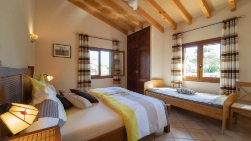 a bedroom with two beds and two windows at Finca Melanie • Cala Santanyí in Santanyi