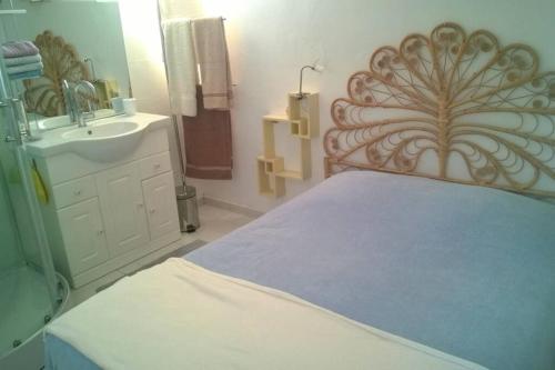 Schlafzimmer mit einem Bett, einem Waschbecken und einem Spiegel in der Unterkunft Gîte à la ferme avec piscine in Bernadets-Debat