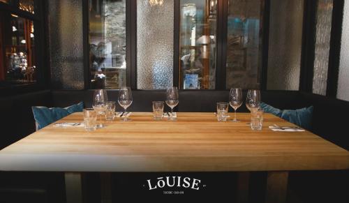 a long wooden table with wine glasses on it at Hotel Port-Royal in Quebec City