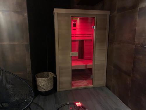 une porte en verre avec lumière rouge dans une pièce dans l'établissement Le Nautile, à Hyères