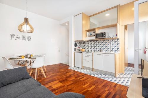 a living room with a couch and a kitchen at RG Downtown Duplex in Faro