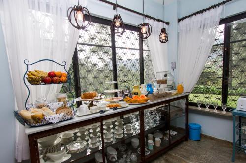 een ontbijttafel met eten erop voor een raam bij Pousada Chácara Aracê in Araras Petropolis