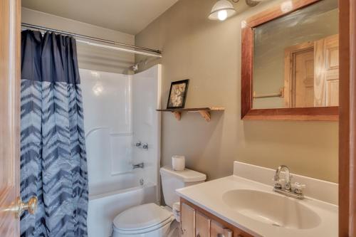 ein Badezimmer mit einem Waschbecken, einem WC und einem Spiegel in der Unterkunft A View to Remember in Sevierville