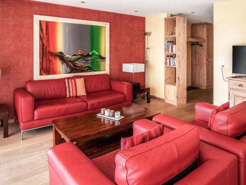 sala de estar con muebles de color rojo y sofá rojo en Apartment Chalet Smaragd-3 by Interhome, en Grindelwald