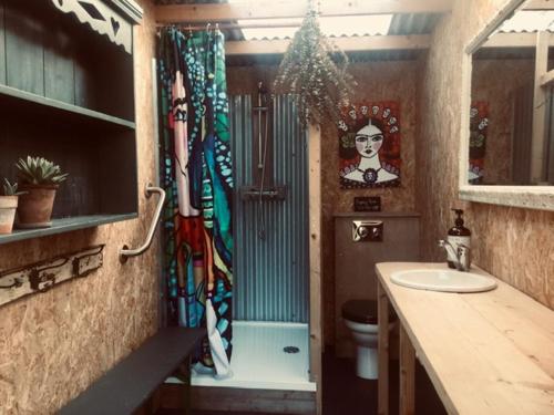 ColkirkにあるThe Oaks Glamping - Magpie Half Shepherds Hutのバスルーム(洗面台、トイレ付)、窓が備わります。