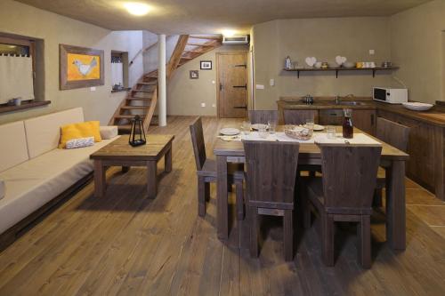 a kitchen and living room with a table and a couch at Panonska Vas Apartments in Moravske Toplice