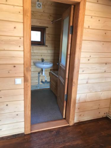 a bathroom in a log cabin with a sink at Kozichky Guest House in Tatariv
