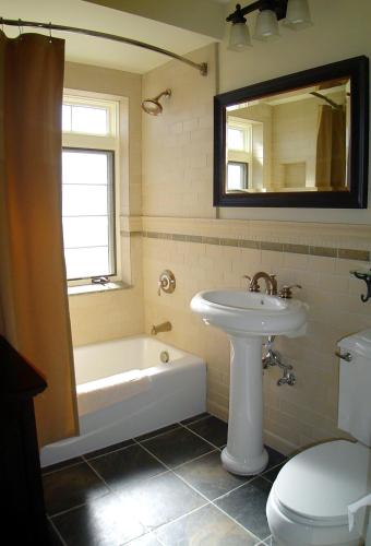a bathroom with a sink and a tub and a toilet at El Tovar - Inside the Park in Grand Canyon Village