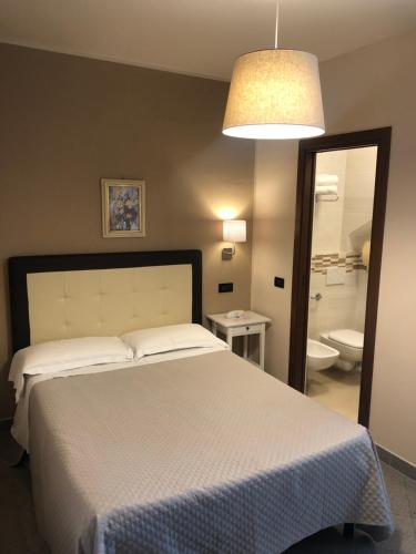 a bedroom with a bed and a bathroom with a toilet at Hotel Di Stefano in Pisa