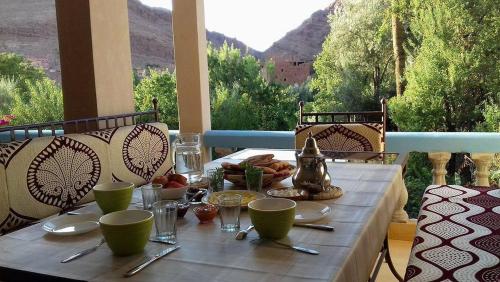 a table with food on it with a view of the mountains at A Secret Garden in Tinerhir