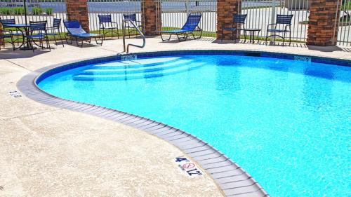 a large swimming pool with blue chairs and chairs at Holiday Inn Express and Suites Bossier City Louisiana Downs by IHG in Bossier City