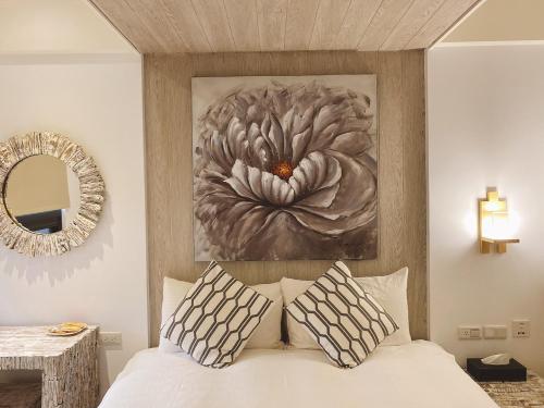 a bedroom with a large flower painting above a bed at Homie B&B in Hualien City