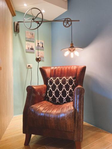 a brown leather chair in a room with a lamp at Homie B&B in Hualien City