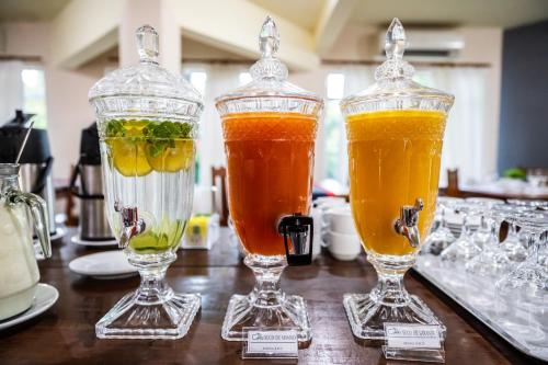 three glass vases filled with different types of drinks at Canzi Cataratas Hotel in Foz do Iguaçu