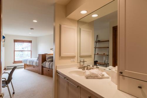 Un baño con lavabo y cama. en Northwood's Ski-In Ski-Out by Vail Realty, en Vail